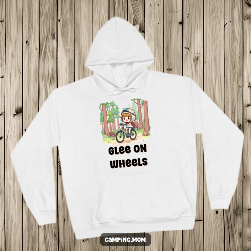 Funny Hoodie: Kawaii camping character bicycling with a joyful expression, through a scenic forest.